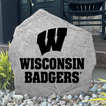 Custom University of Wisconsin Logo Stone displayed in a landscaped flower bed, showcasing officially licensed Wisconsin Badgers artwork with permanent engraving. This decorative outdoor stone creates a beautiful focal point for alumni homes and Badger fans.
