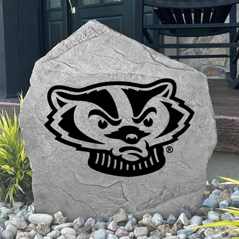 Custom Wisconsin Badger Stone displayed in a landscaped flower bed, showcasing officially licensed Bucky Badger artwork with permanent engraving. This decorative outdoor stone creates a bold focal point for alumni homes and Wisconsin fans.