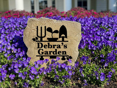 Outdoor decorative garden name stone with rustic engraved design.