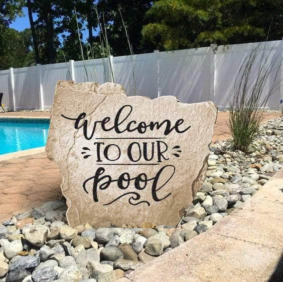 Poolside landscape stone featuring the message "Welcome To Our Pool," perfect for creating a fun and inviting backyard oasis.