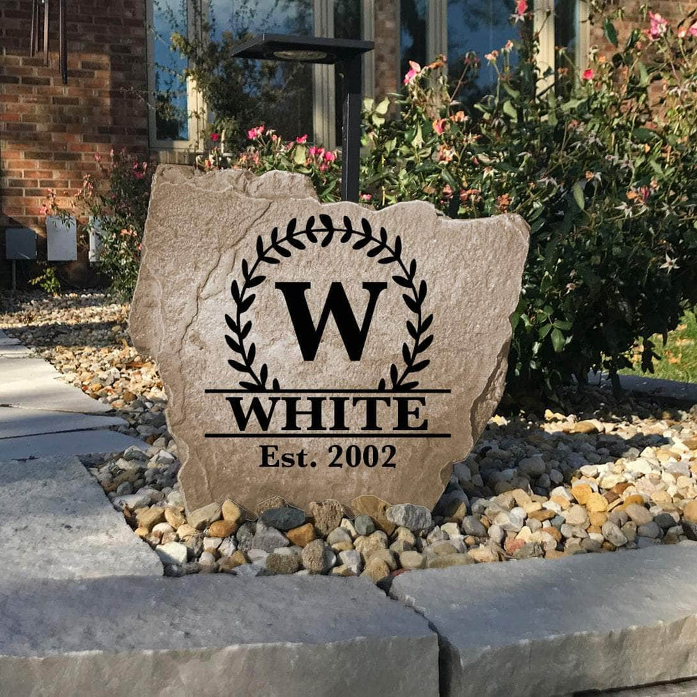 Handcrafted engraved family monogram monument combining scrolling vine artwork, a personalized surname, and an established year for a sophisticated outdoor accent.