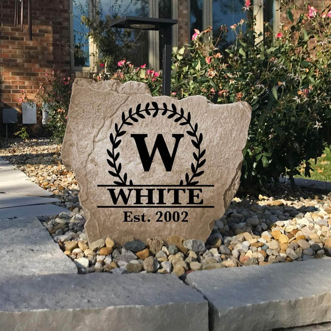 Handcrafted engraved family monogram monument combining scrolling vine artwork, a personalized surname, and an established year for a sophisticated outdoor accent.