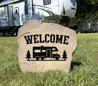 Motorhome welcome sign carved into natural stone for campsite or yard.
