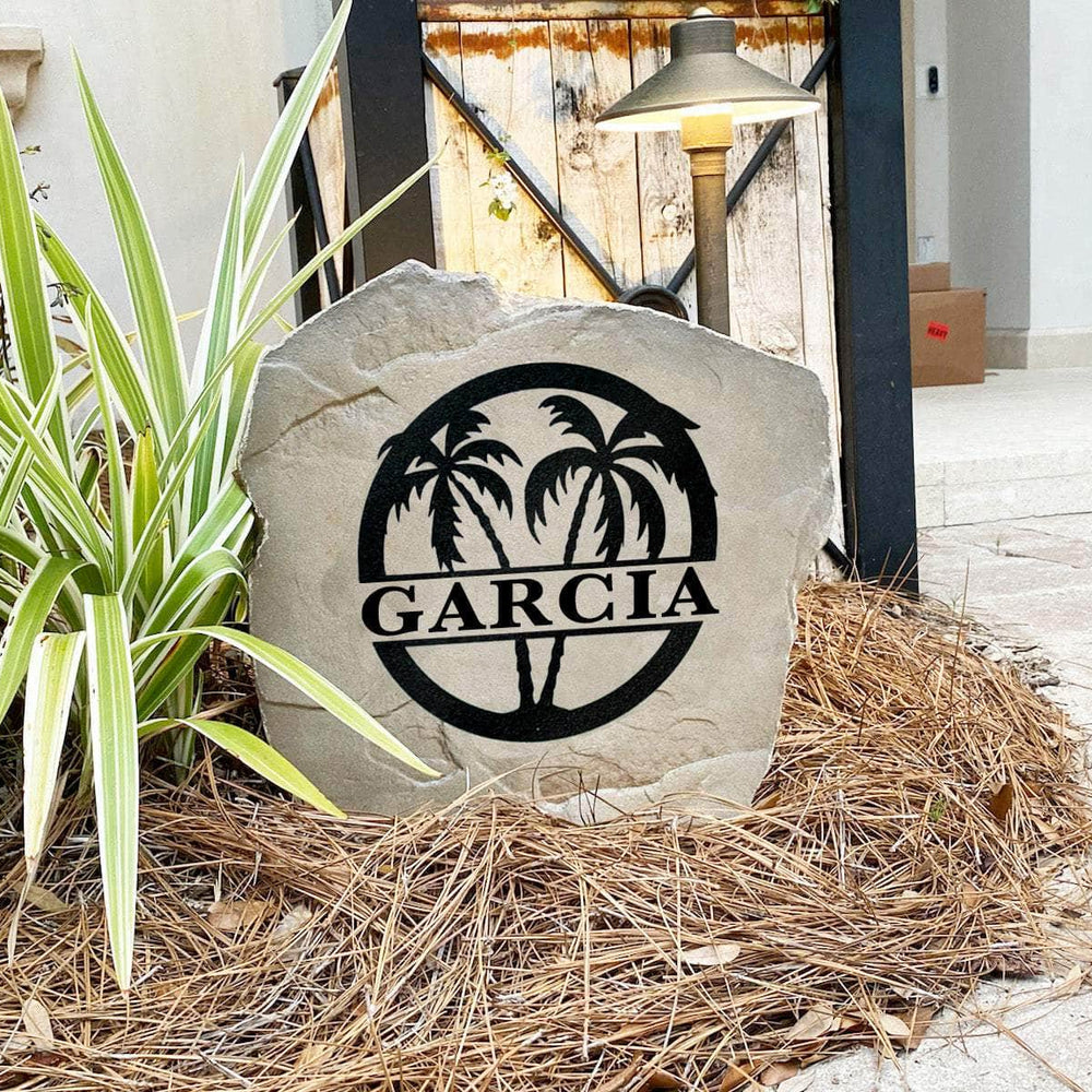 Decorative tropical monogram landscape stone featuring graceful palm trees and personalized engraving for beach homes, lake houses, and backyard retreats.