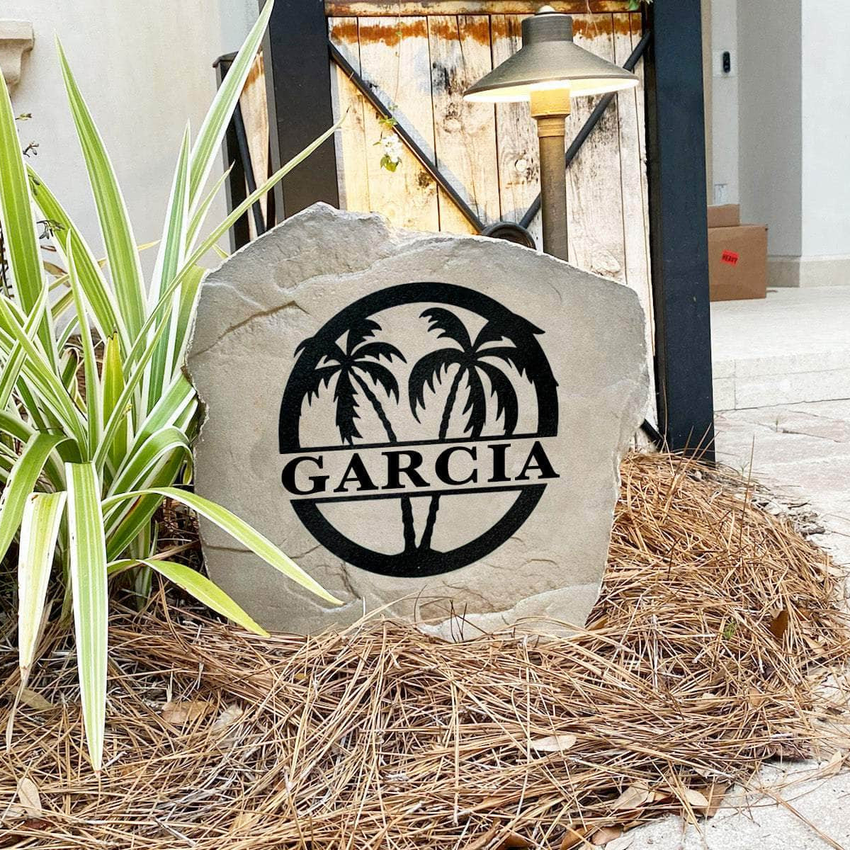Decorative tropical monogram landscape stone featuring graceful palm trees and personalized engraving for beach homes, lake houses, and backyard retreats.